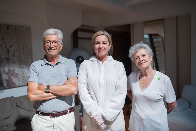 Group portrait of caregivers with senior adults in a home setting.